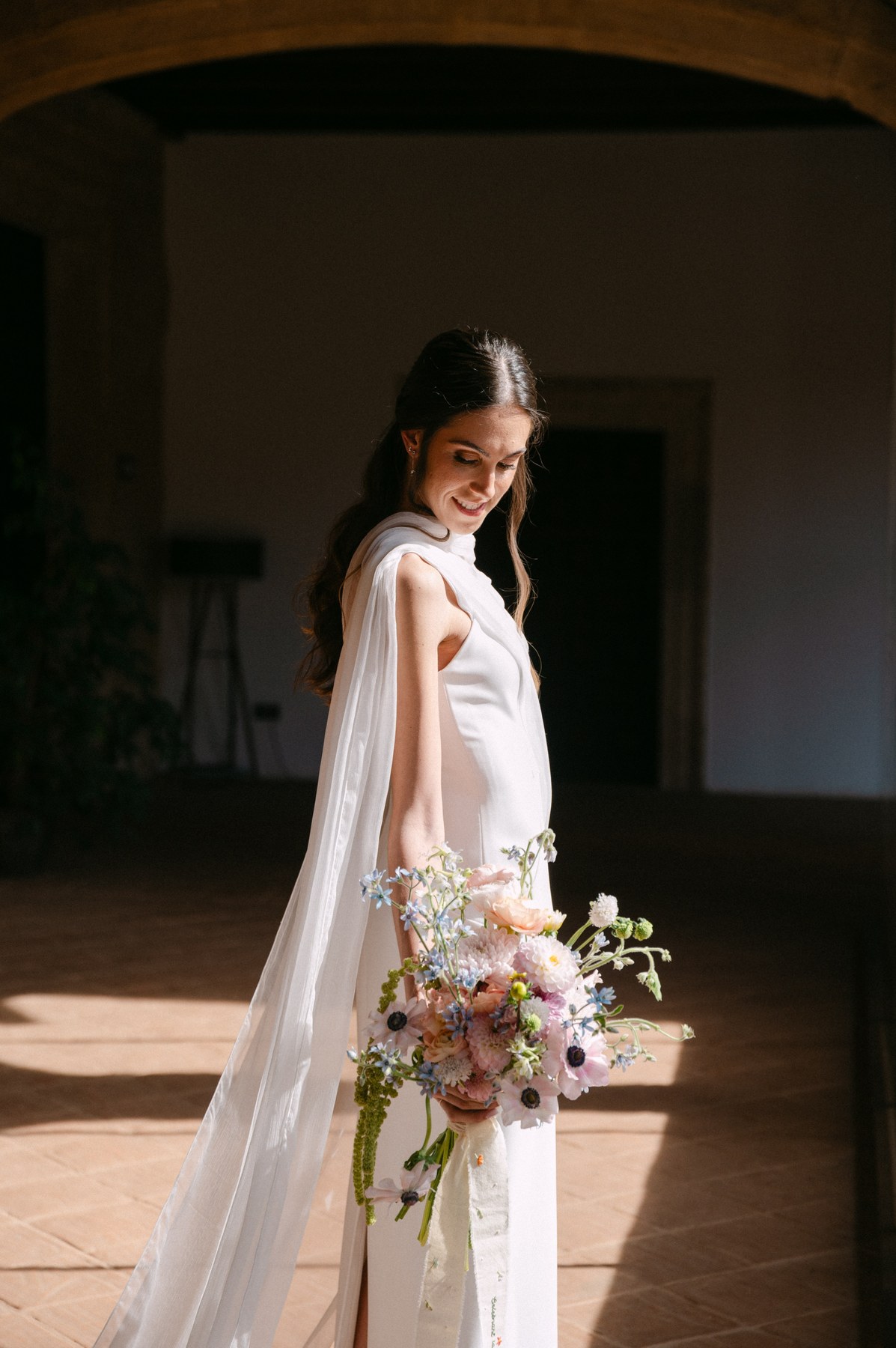 La novia en el pasillo con su ramo — boda de Yolanda y Javier en Dehesa de Canónigos, Valladolid