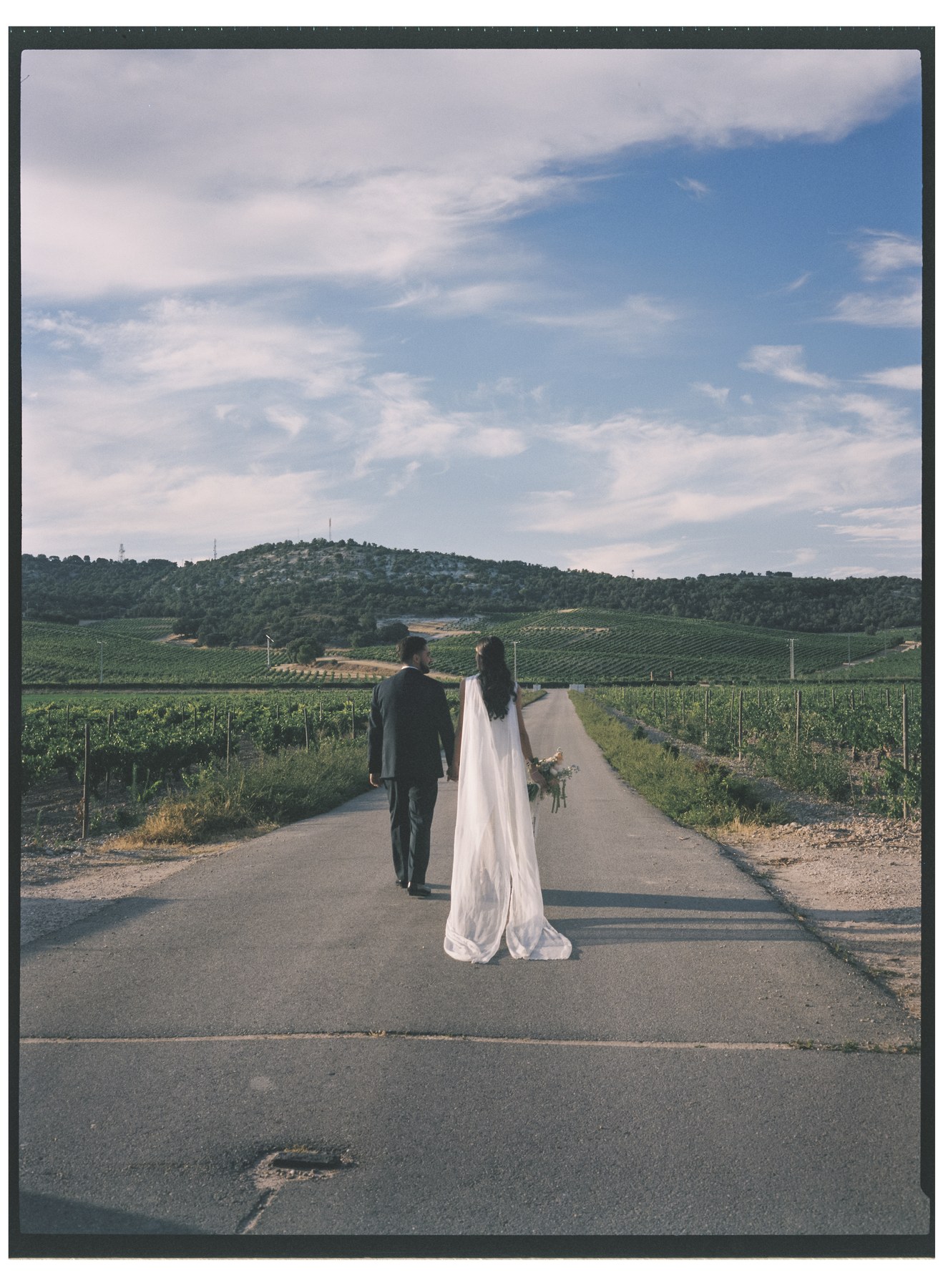 Beso robado durante el cóctel — boda de Yolanda y Javier en Dehesa de Canónigos, Valladolid · en 120mm